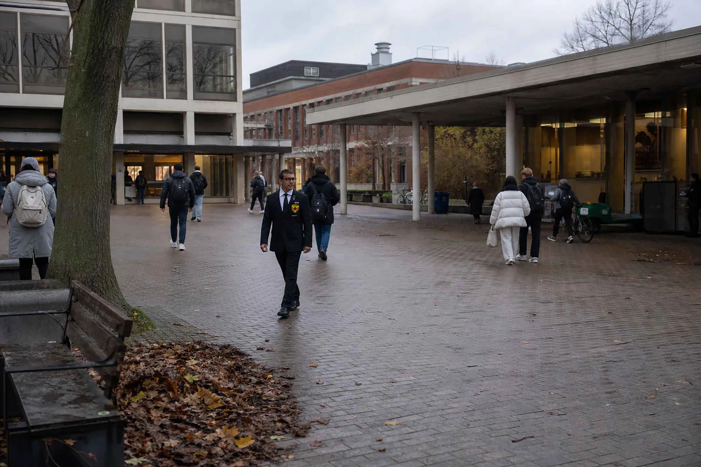 A-AARON security guard checking an emergency call point on an active university campus